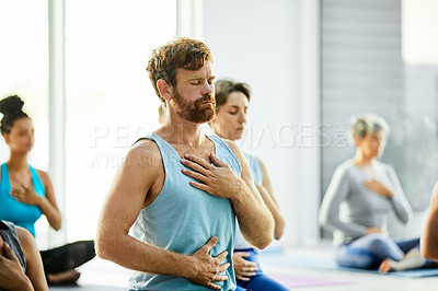 Buy stock photo Shot of a group of men and women meditating during a yoga class