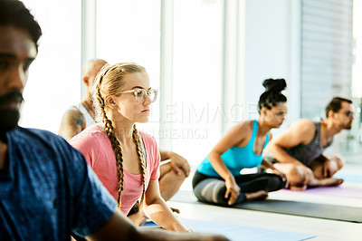 Buy stock photo Shot of a group of women practicing yoga in a fitness class