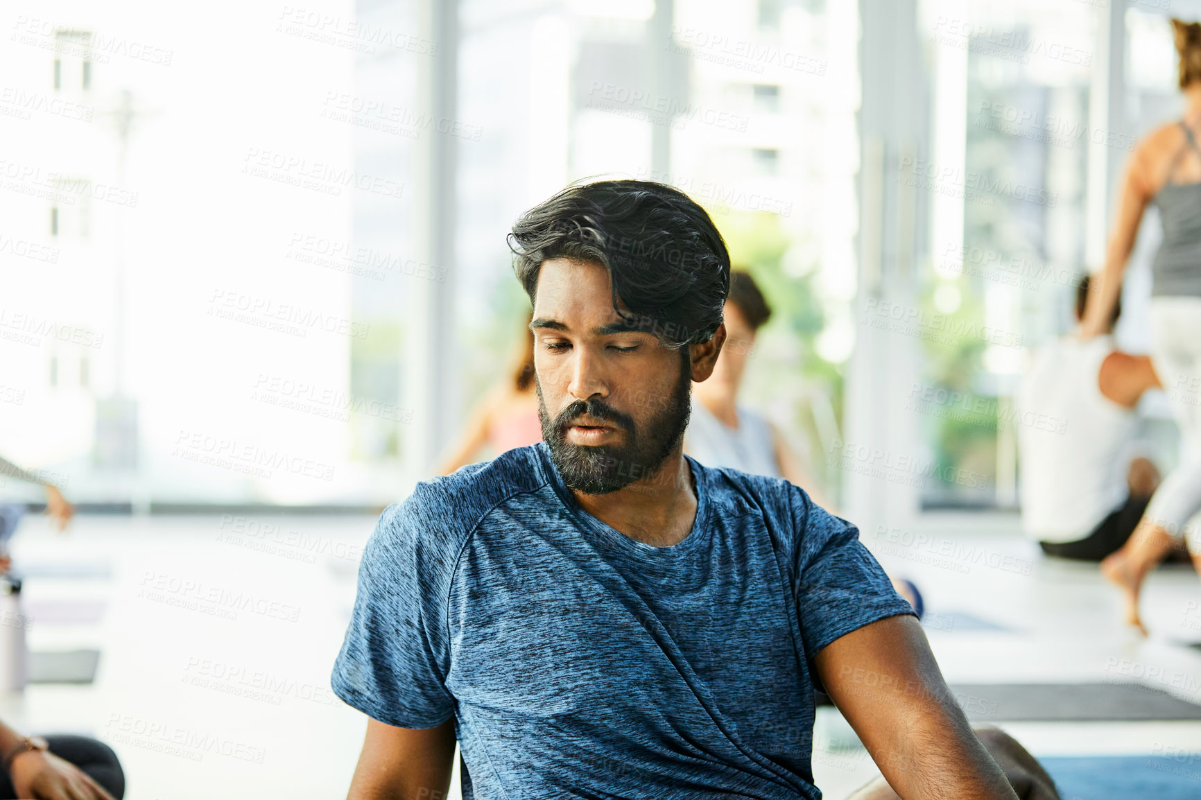 Buy stock photo Shot of a young man practicing yoga in a fitness class