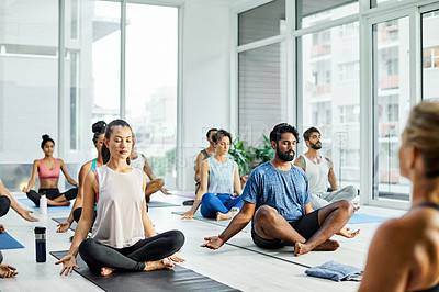 Buy stock photo Shot of a group of men and women meditating during a yoga class