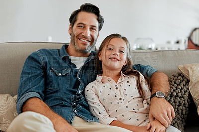 Buy stock photo Shot of a man and his daughter sitting together on the couch at home