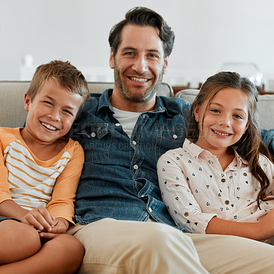 Buy stock photo Shot of a young boy and girl sitting at home with their father