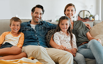 Buy stock photo Shot of a happy couple sitting at home with their two young children