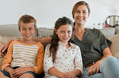 Buy stock photo Shot of a young boy and girl sitting at home with their mother