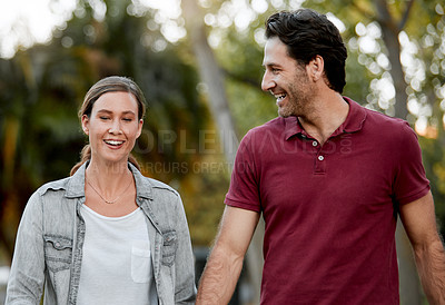 Buy stock photo Cropped shot of an affectionate couple taking a walk through the park