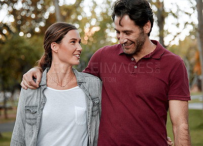 Buy stock photo Cropped shot of an affectionate couple taking a walk through the park