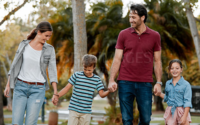 Buy stock photo Shot of a couple with two kids taking a walk through the park together