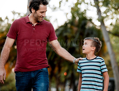 Buy stock photo Shot of a man and his son taking a walk through the park