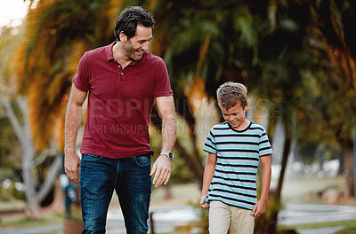Buy stock photo Shot of a man and his son taking a walk through the park