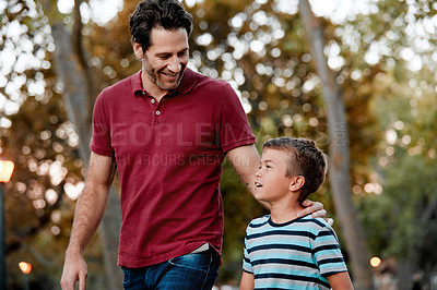 Buy stock photo Shot of a man and his son taking a walk through the park