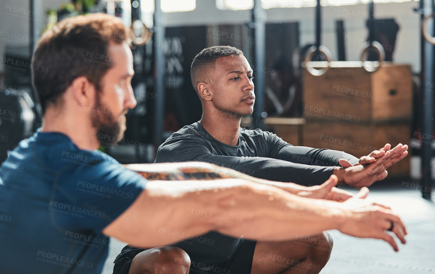 Buy stock photo Cropped shot of a group of young athletes going through their warmup routine in the gym
