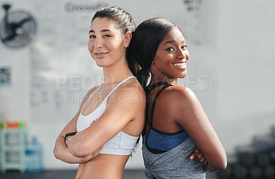 Buy stock photo Cropped portrait of two attractive young female athletes standing back to back in the gym