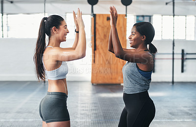 Buy stock photo Cropped shot of two attractive young female athletes high-fiving during a workout in the gym