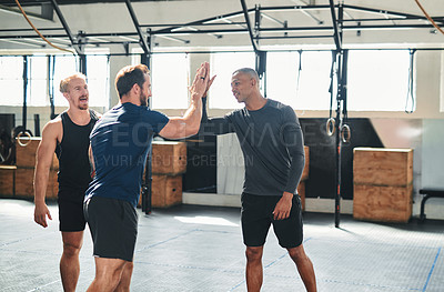 Buy stock photo Cropped shot of two handsome young male athletes high-fiving during a workout in the gym
