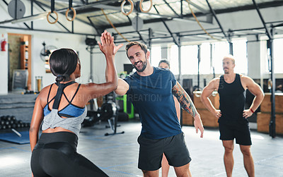 Buy stock photo Cropped shot of two young athletes high-fiving during a workout in the gym