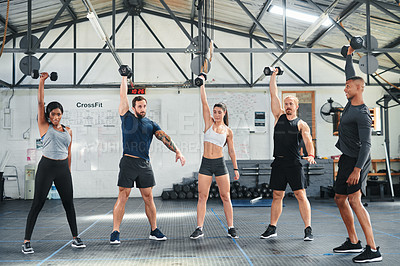 Buy stock photo Full length shot of a group of young athletes going through their warmup routine in the gym