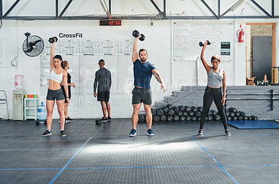 Buy stock photo Shot of a group of young athletes in an exercise class at the gym