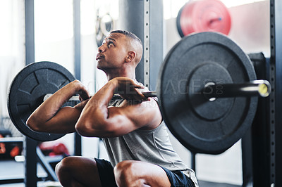 Buy stock photo Cropped shot of a young man working out with a barbell at the gym