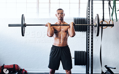 Buy stock photo Cropped shot of a young man working out with a barbell at the gym