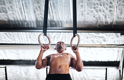 Buy stock photo Shot of a man working out with gymnastic rings