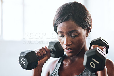 Buy stock photo Cropped shot of a fit young woman working out with dumbbells