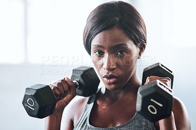 Buy stock photo Cropped shot of a fit young woman working out with dumbbells