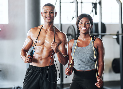 Buy stock photo Portrait shot of two young athletes using skipping ropes while working out at the gym