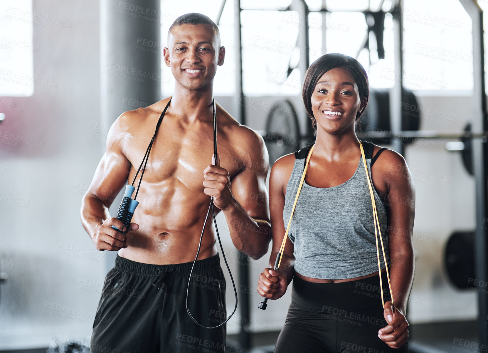 Buy stock photo Portrait shot of two young athletes using skipping ropes while working out at the gym