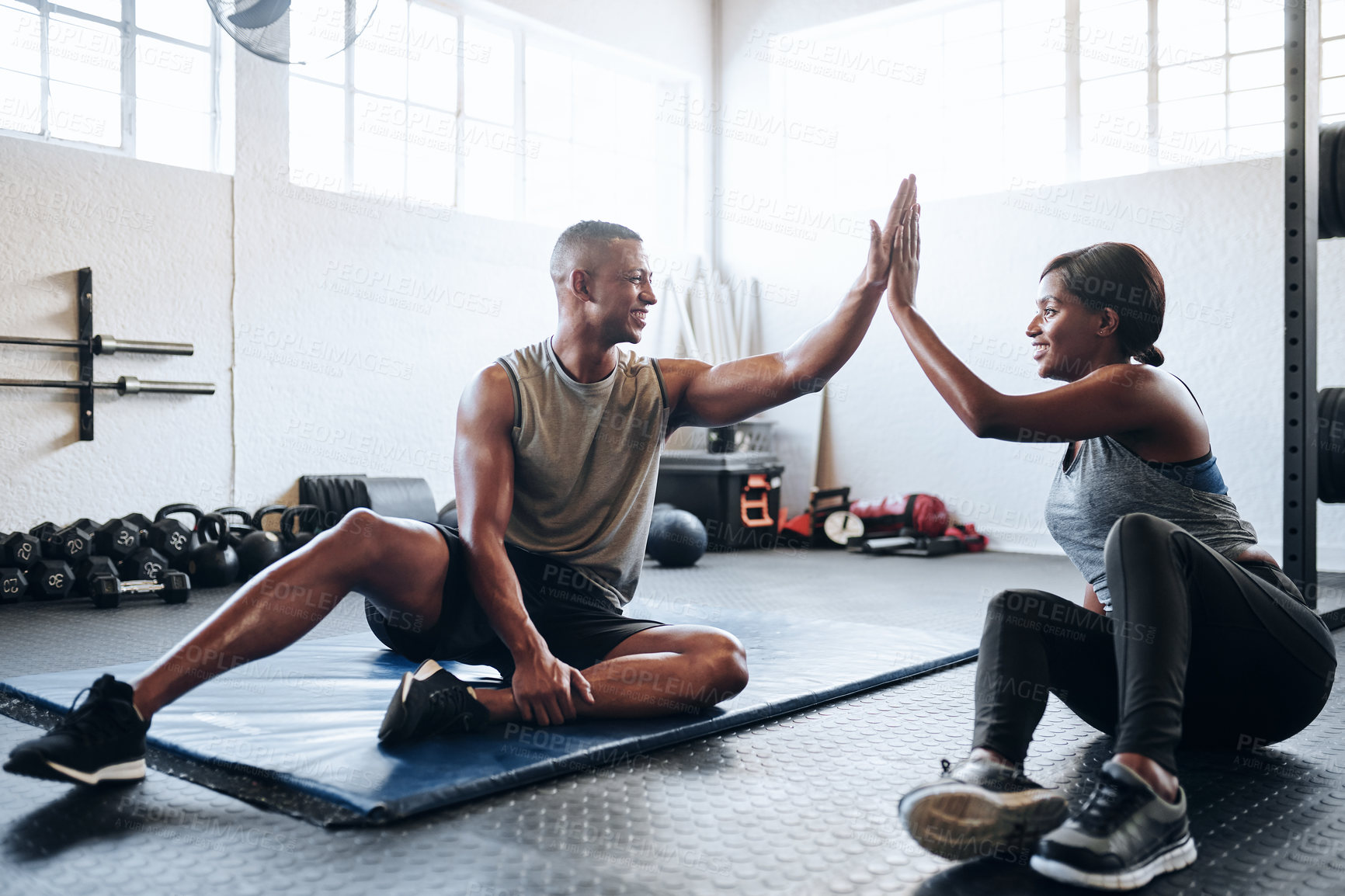 Buy stock photo Shot of a man and his coach giving each other a high-five after his workout