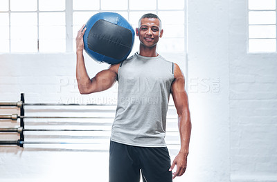 Buy stock photo Portrait of a muscular young man holding up a medicine ball