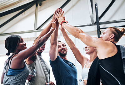 Buy stock photo Shot of a group of people joining their hands together while working out at the gym