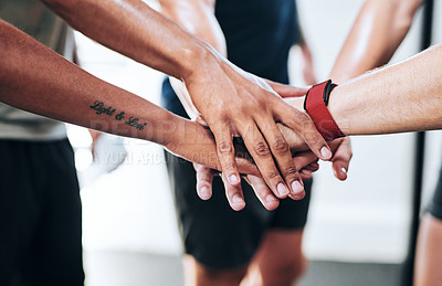 Buy stock photo Shot of a group of people joining their hands together while working out at the gym