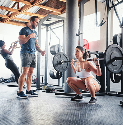 Buy stock photo Shot of a woman working out with the help of her coach at the gym