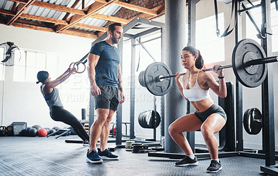 Buy stock photo Shot of a woman working out with the help of her coach at the gym