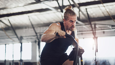 Buy stock photo Shot of a young man working out on an exercise bike in a gym