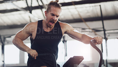Buy stock photo Shot of a young man working out on an exercise bike in a gym