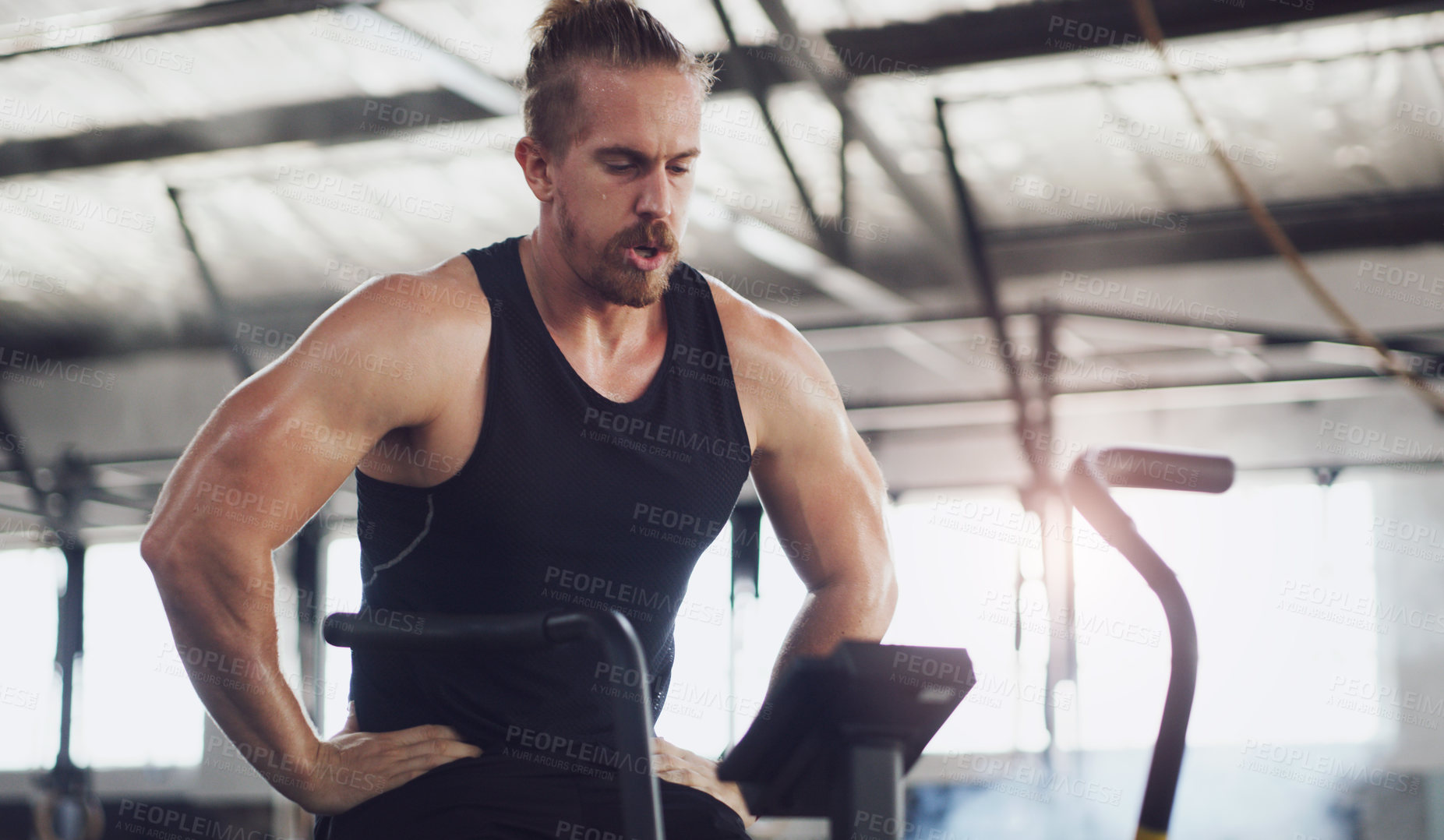Buy stock photo Tired, stationary bike and fitness with man in gym for health, workout machine and recovery. Exercise rest, breathing and training equipment with person in sports club for cycling and exhausted