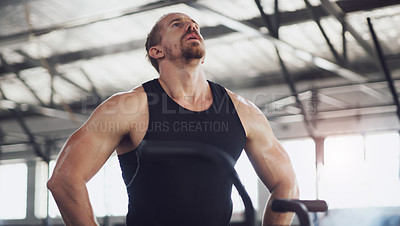 Buy stock photo Shot of a young man taking a break while working out on an exercise bike in a gym