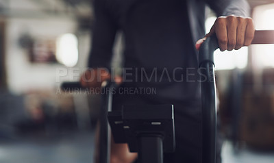 Buy stock photo Closeup shot of an un recognisable man working out on an exercise bike in a gym
