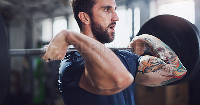 Buy stock photo Shot of a young man exercising with a barbell in a gym