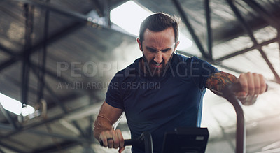 Buy stock photo Shot of a young man working out on an exercise bike in a gym