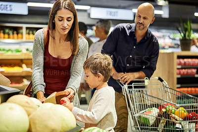 Buy stock photo Shot of a family shopping for groceries in a supermarket