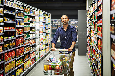 Buy stock photo Shot of a man shopping for grocery in a supermarket
