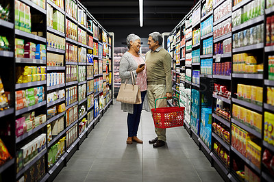 Buy stock photo Shot of a elderly couple grocery shopping in a supermarket