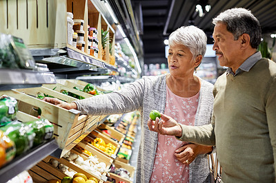 Buy stock photo Shot of a elderly couple grocery shopping in a supermarket