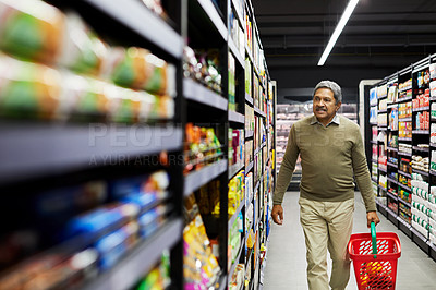 Buy stock photo Shot of a mature male shopping for groceries in a supermarket