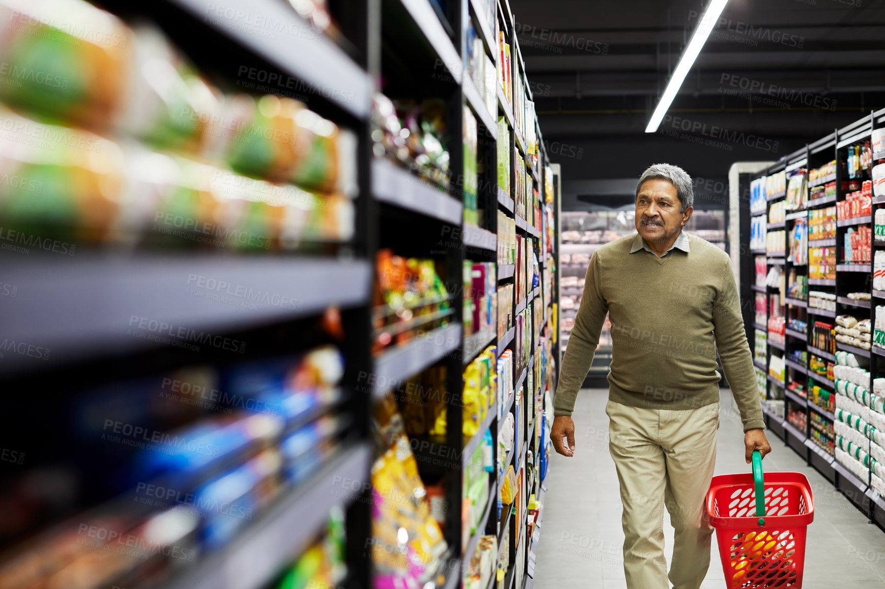 Buy stock photo Shot of a mature male shopping for groceries in a supermarket