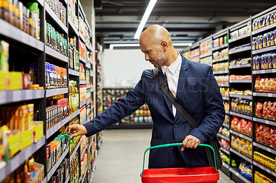 Buy stock photo Shot of a mature male shopping for groceries in a supermarket