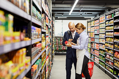 Buy stock photo Shot of a store worker helping a customer in a supermarket