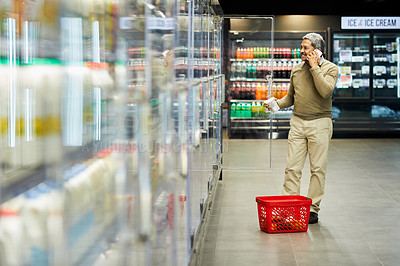 Buy stock photo Shot of a mature male shopping for groceries in a supermarket